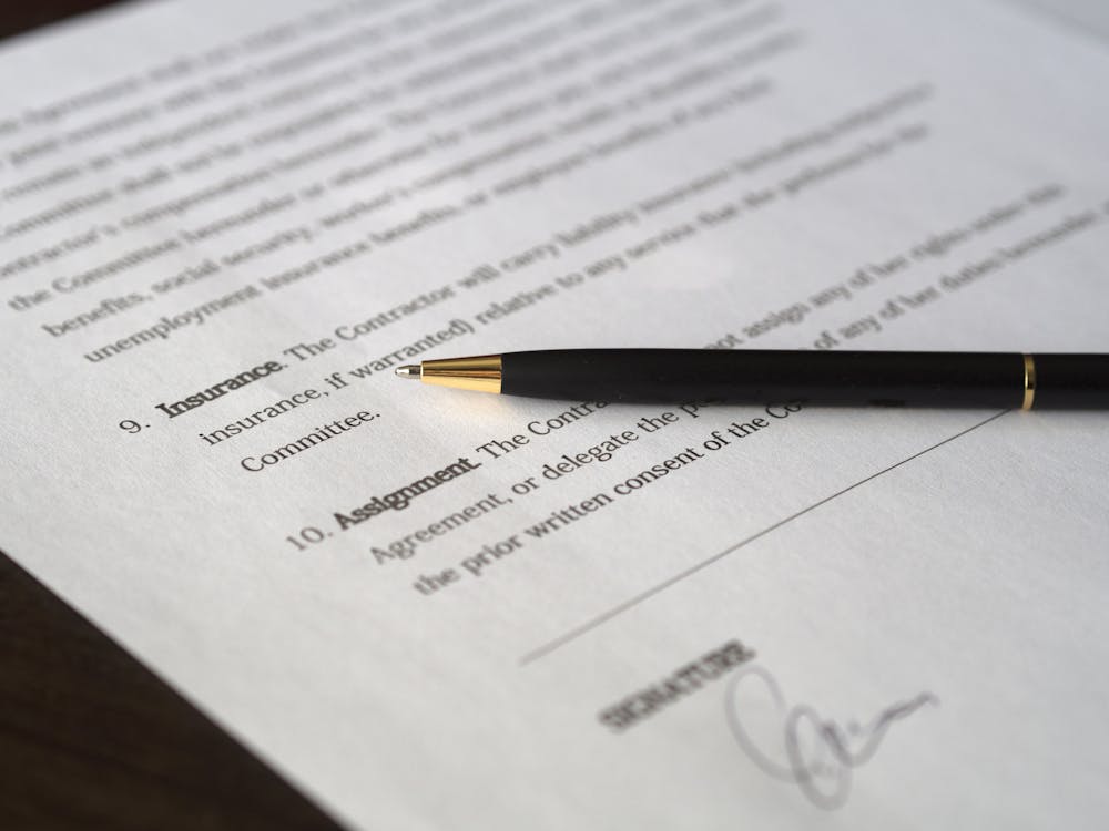 a pen on a contract, representing the importance of good software documentation principles