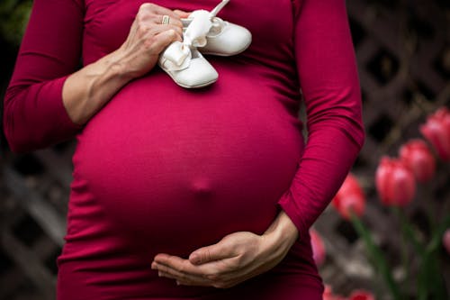 Zwangere Vrouw Met Baby's Schoenen