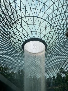 Interior view of Jewel Changi Airport's iconic waterfall and lush greenery.