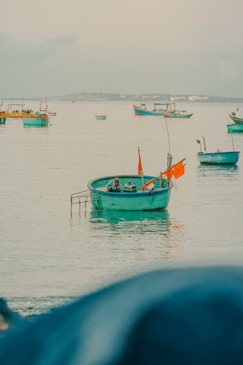 A group of boats in the water with orange flags