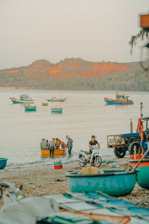 A beach with boats and people on it