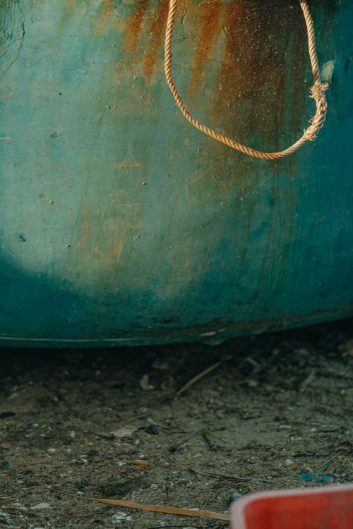 Free Close-up of a weathered boat with rust and rope on a sandy beach in Phan Thiet, Vietnam. Stock Photo