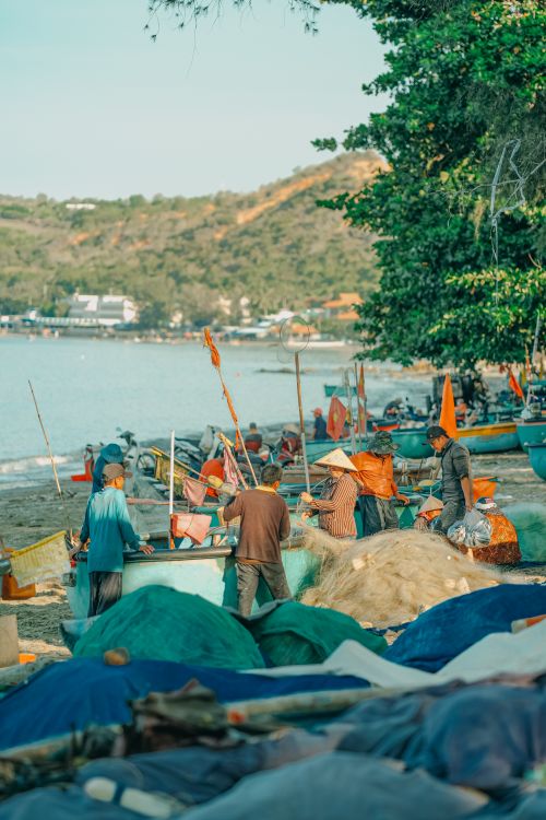 Free Local fishermen prepare their basket boats on a sunny beach in Phan Thiet, Vietnam. Stock Photo