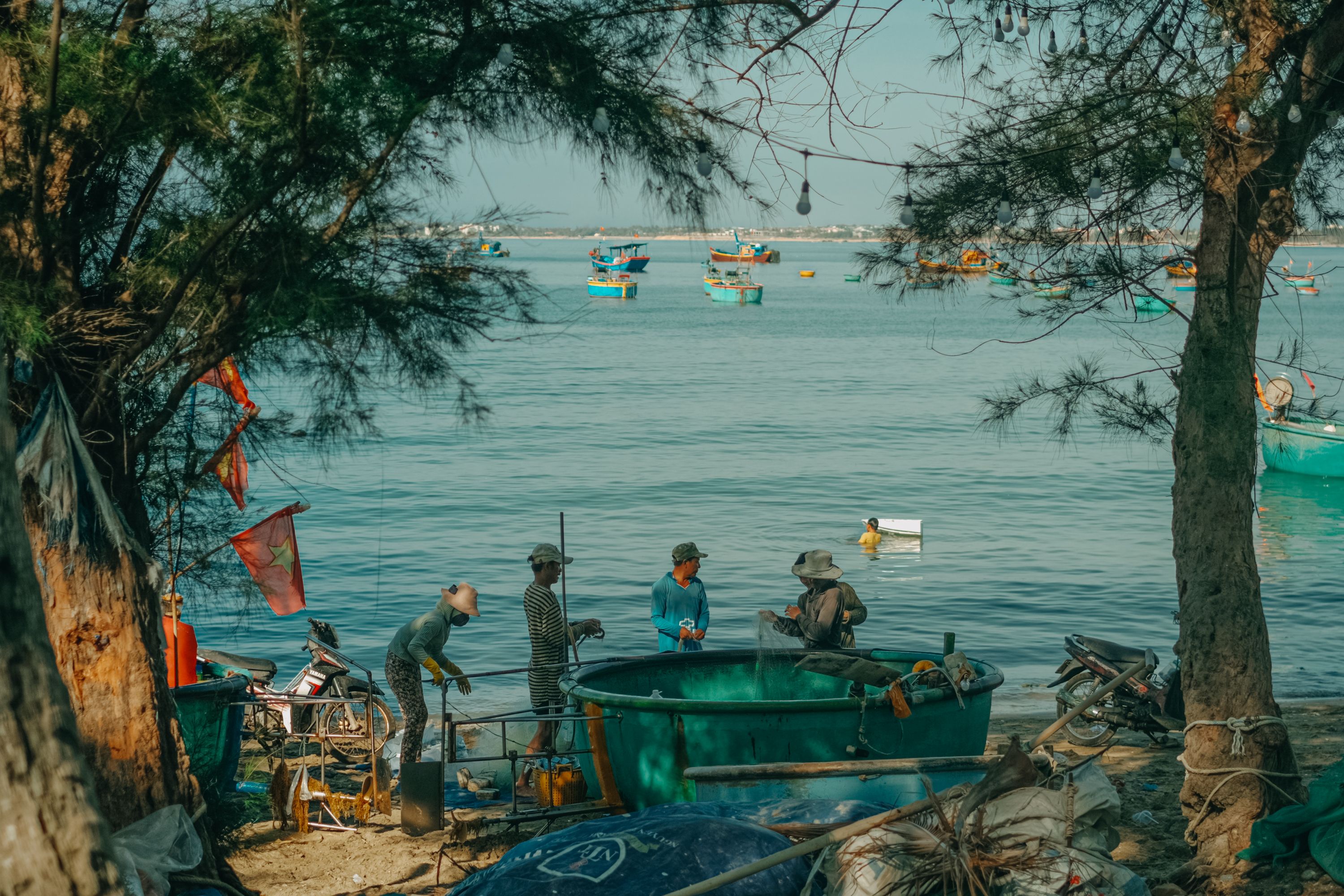 Fishermen engage in daily tasks by the sea in Phan Thiet, Vietnam.
