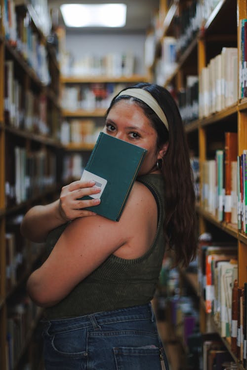 A woman holding a book in a library