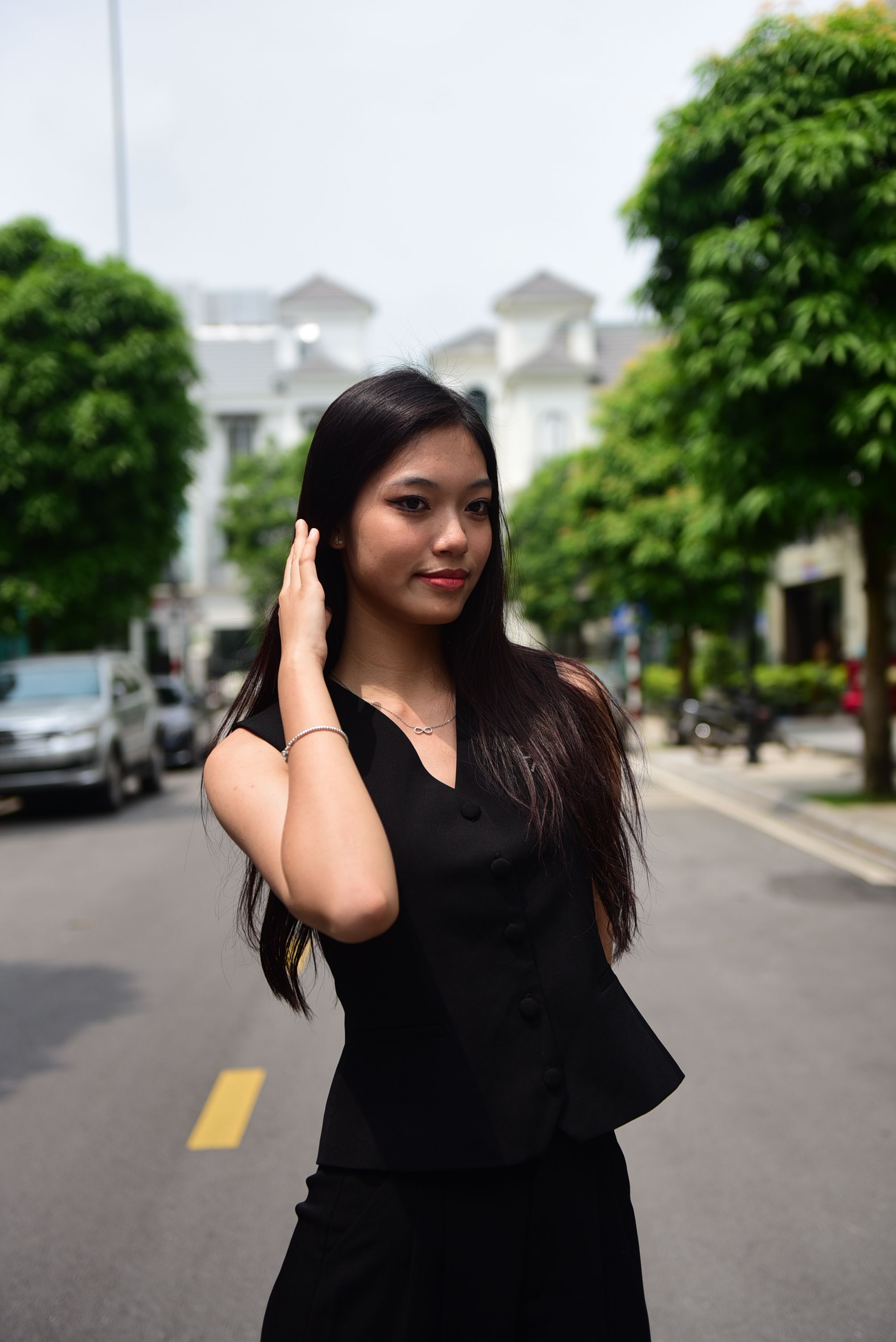 A woman in a black suit posing on the street · Free Stock Photo