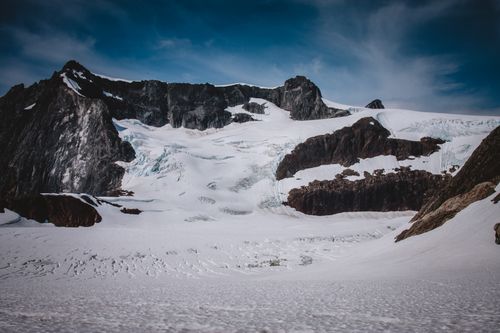 Free A stunning view of a snow-covered mountain range under a clear blue sky, capturing nature's grandeur. Stock Photo