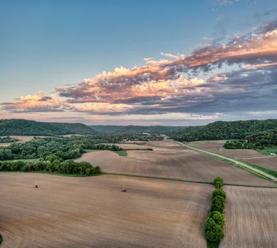 Stunning sunset aerial view of Weaver, MN's rural landscape showcasing fields and forests.