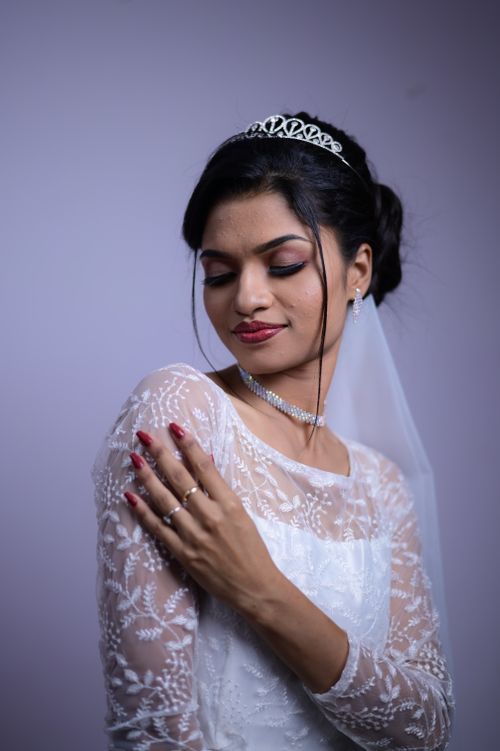 Free Captivating bridal portrait featuring a bride in a lace gown with elegant jewelry, tiara, and veil. Stock Photo