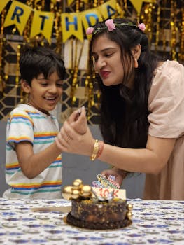 Mother and son sharing a joyful birthday celebration with cake and smiles.