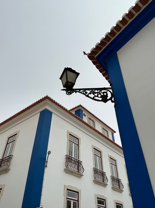 Free Charming blue and white building architecture in Ericeira, Portugal, featuring decorative lamp post. Stock Photo
