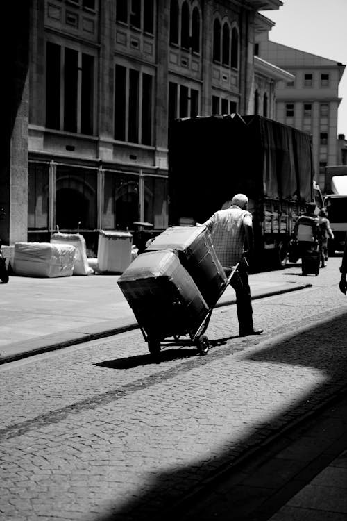 A man pushing a cart down the street