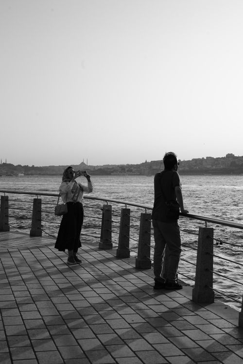 Free Black and white photo of a couple on a pier, capturing a picturesque sea view. Stock Photo