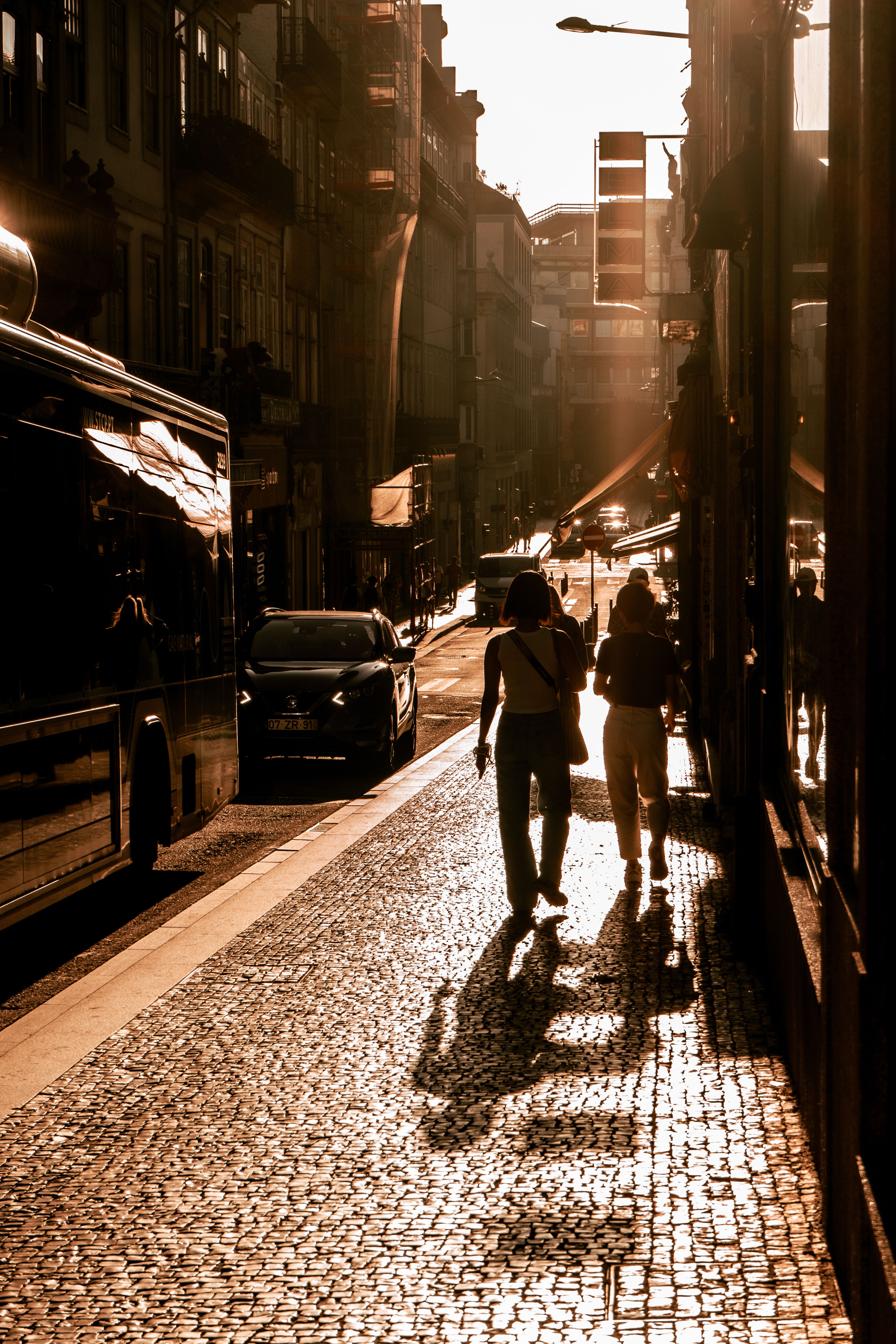 Silhouettes of People Walking down Street at Sunset · Free Stock Photo