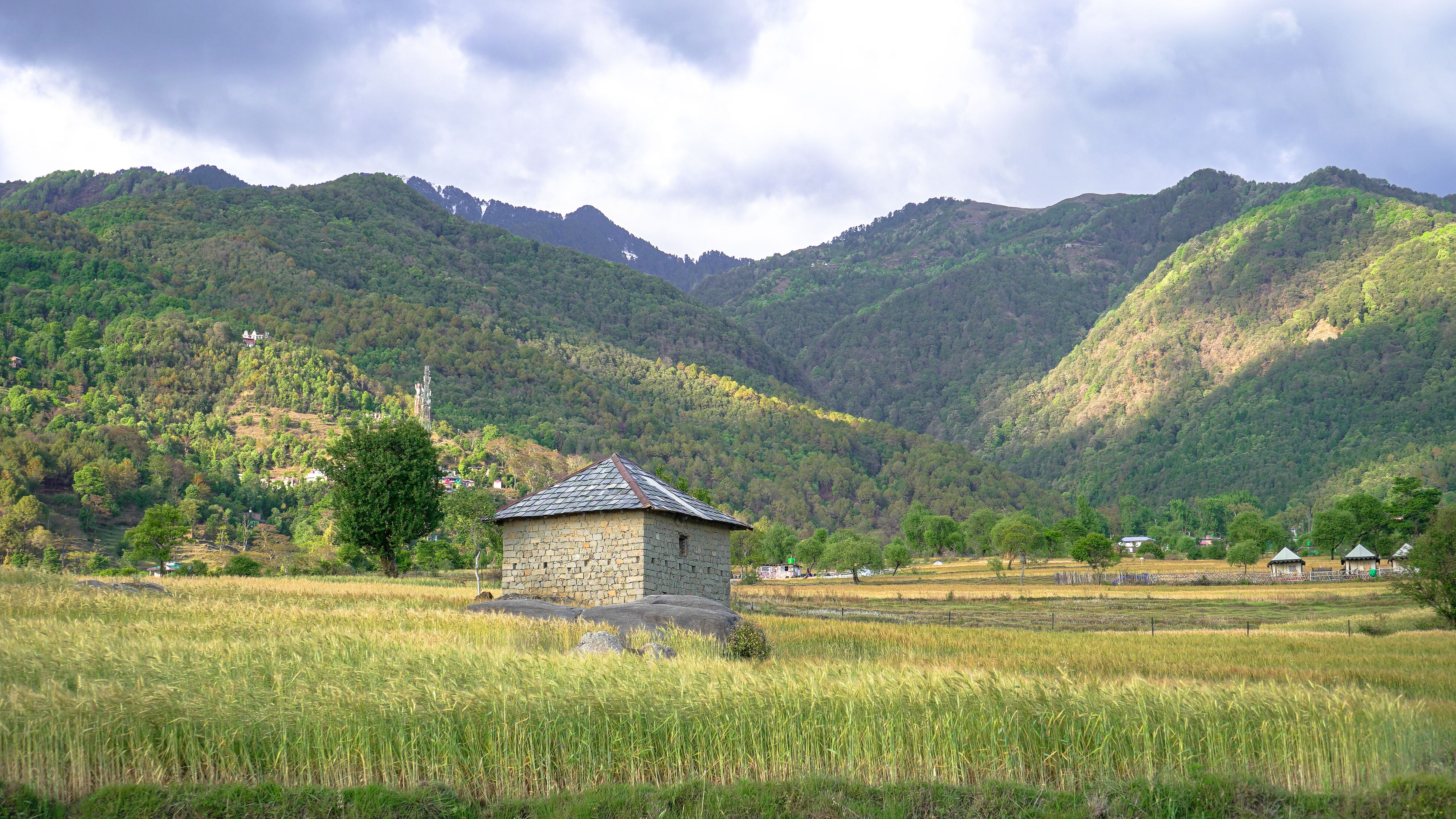 Beautiful landscape of Bir Valley in Himachal Pradesh with traditional stone building.