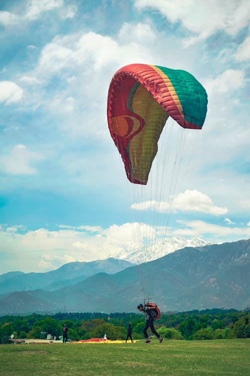 man trying to learn paragliding under ice caped mountains