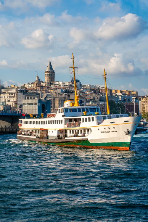 Free Scenic view of a ferry passing the iconic Galata Tower on the Bosphorus in Istanbul, Turkey. Stock Photo