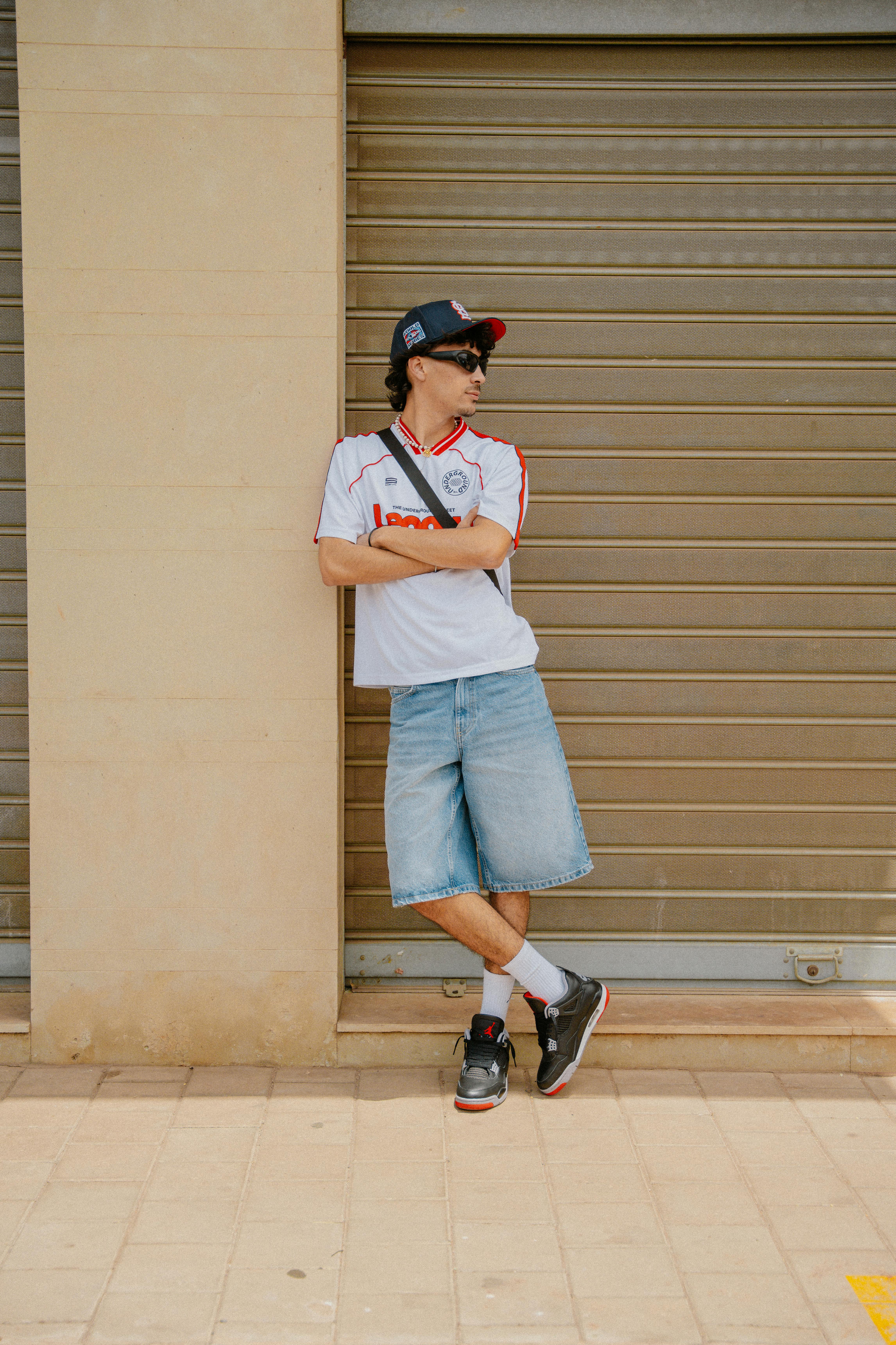 Homme en maillot de foot avec jean et casquette — look streetwear