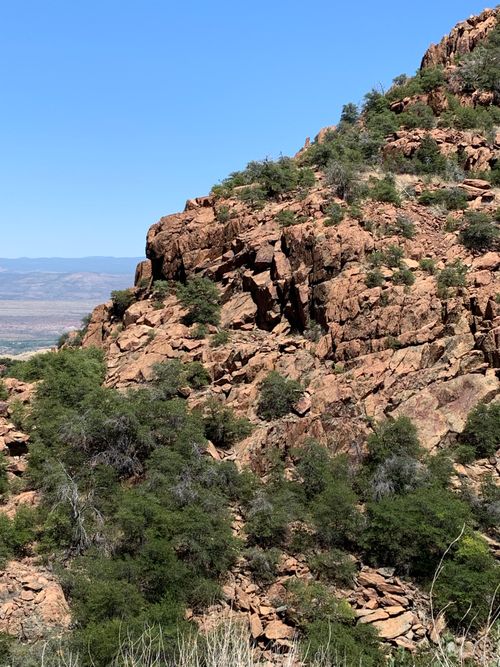 Free Breathtaking view of a rocky mountain landscape with scattered greenery under a clear blue sky. Stock Photo