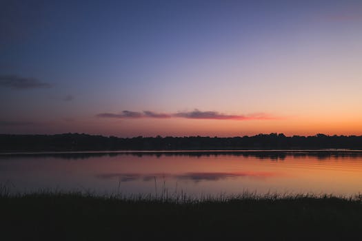 Serene sunrise over a lake in Stamford, Connecticut, showcasing vibrant colors and reflections.