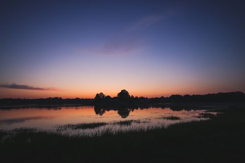 Free Serene lakeside sunset reflecting tranquil waters in Stamford, CT. Stock Photo