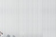 一名女子的剪影在波纹金属墙壁上奔跑，展现了极简主义的设计和轻松的玩法