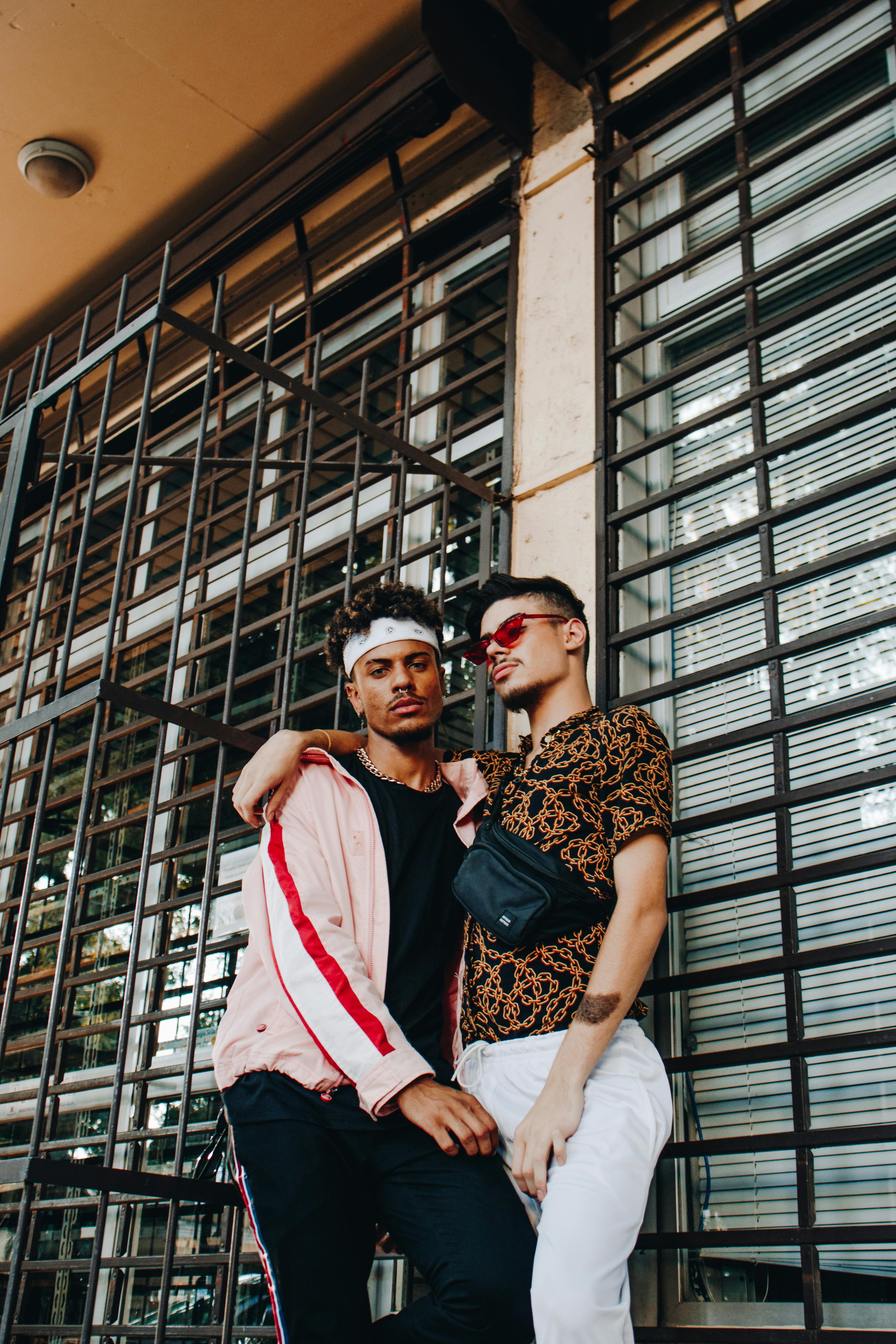 两位时尚男士在城市中随意摆姿，展现友谊与现代风尚