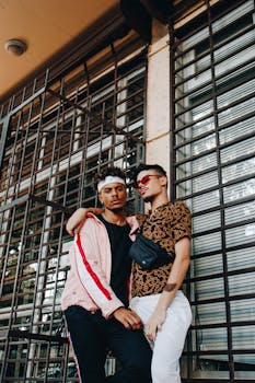 两位时尚男士在城市中随意摆姿，展现友谊与现代风尚