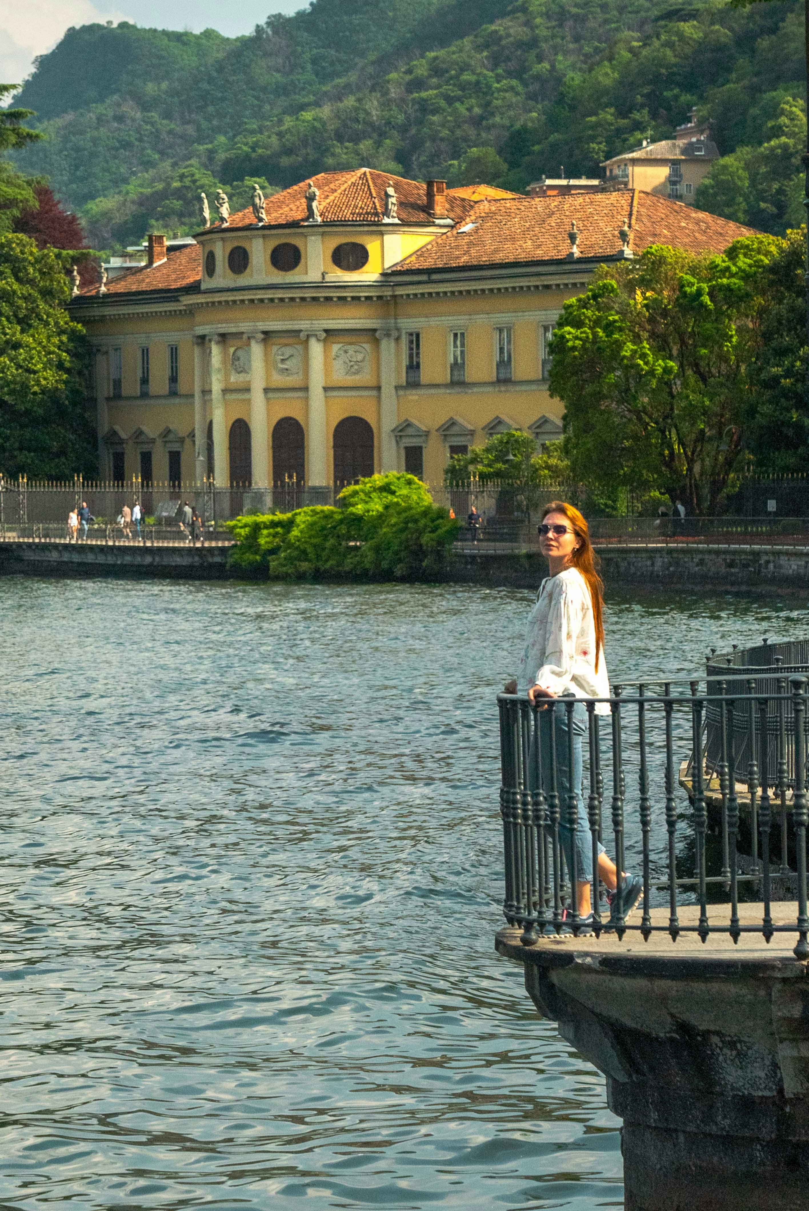 Villa Olmo in Como, a grand neoclassical lakefront estate surrounded by a large public park with shaded pathways and manicured gardens, set on the scenic western shore of Lake Como