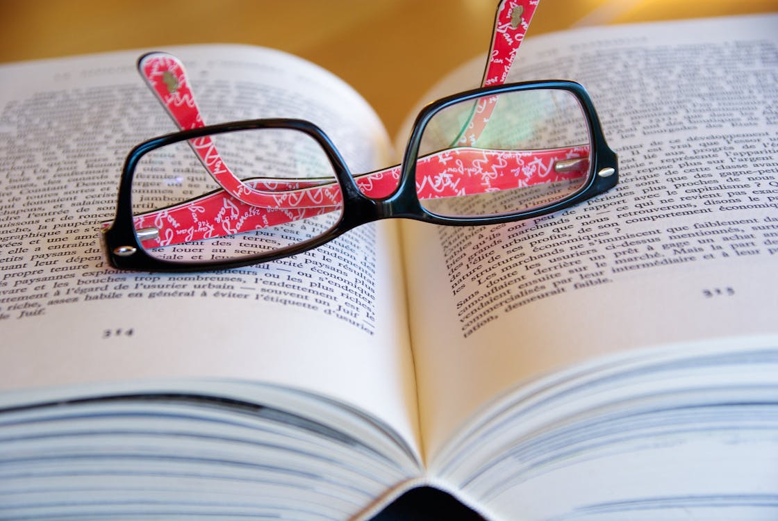 Gratis Kacamata Berbingkai Hitam Di Halaman Buku Foto Stok