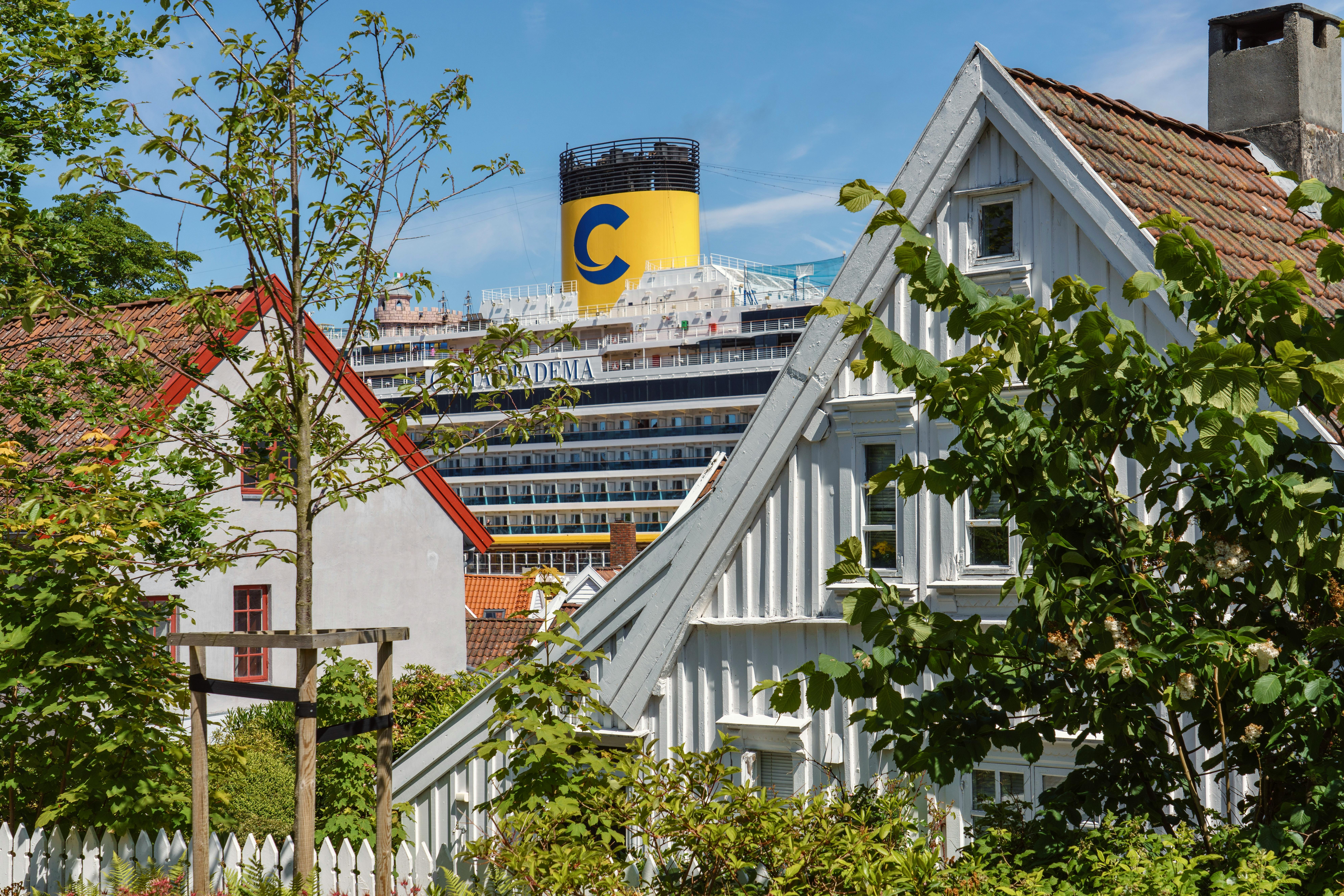Picturesque residential houses in Stavanger with a cruise ship in the background, capturing urban and maritime blend.