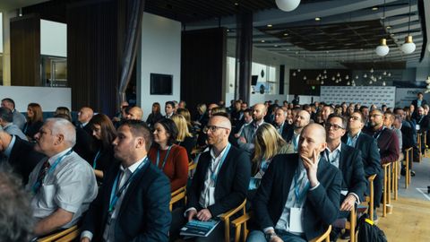 Business professionals attentively listening at an indoor conference meeting.