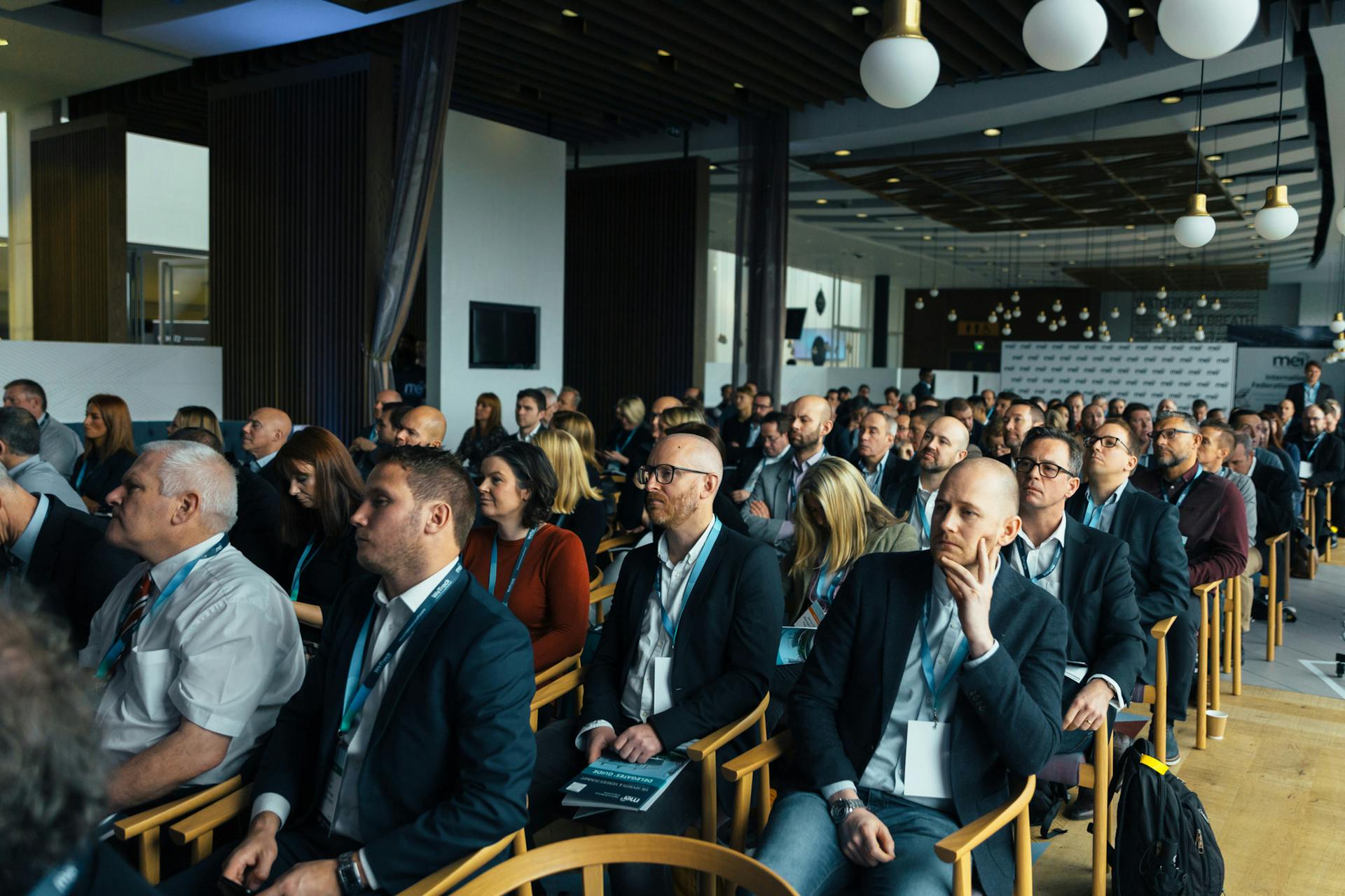 Business professionals attentively listening at an indoor conference meeting.