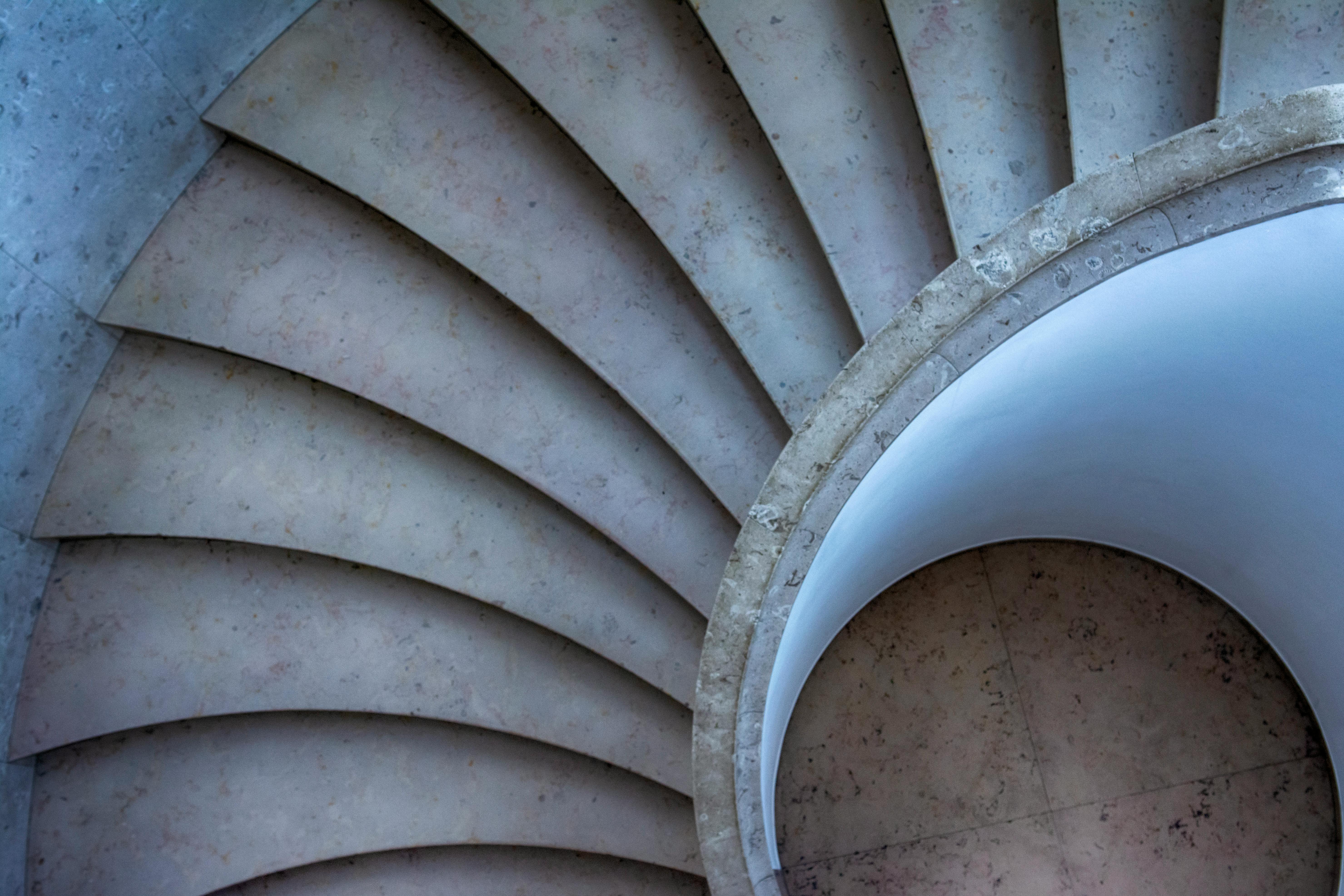 A stunning top-down view of a spiral stone staircase with elegant curves and lines.