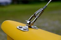 户外亮黄色表面上固定金属钢丝绳的详细视图