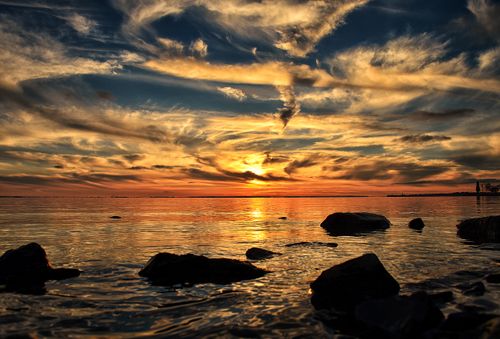 Free Captivating sunset seascape with vibrant sky reflecting over calm ocean waters. Stock Photo