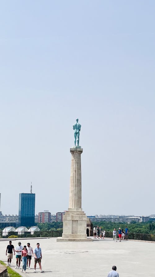 Free A statue of a man in front of a city Stock Photo