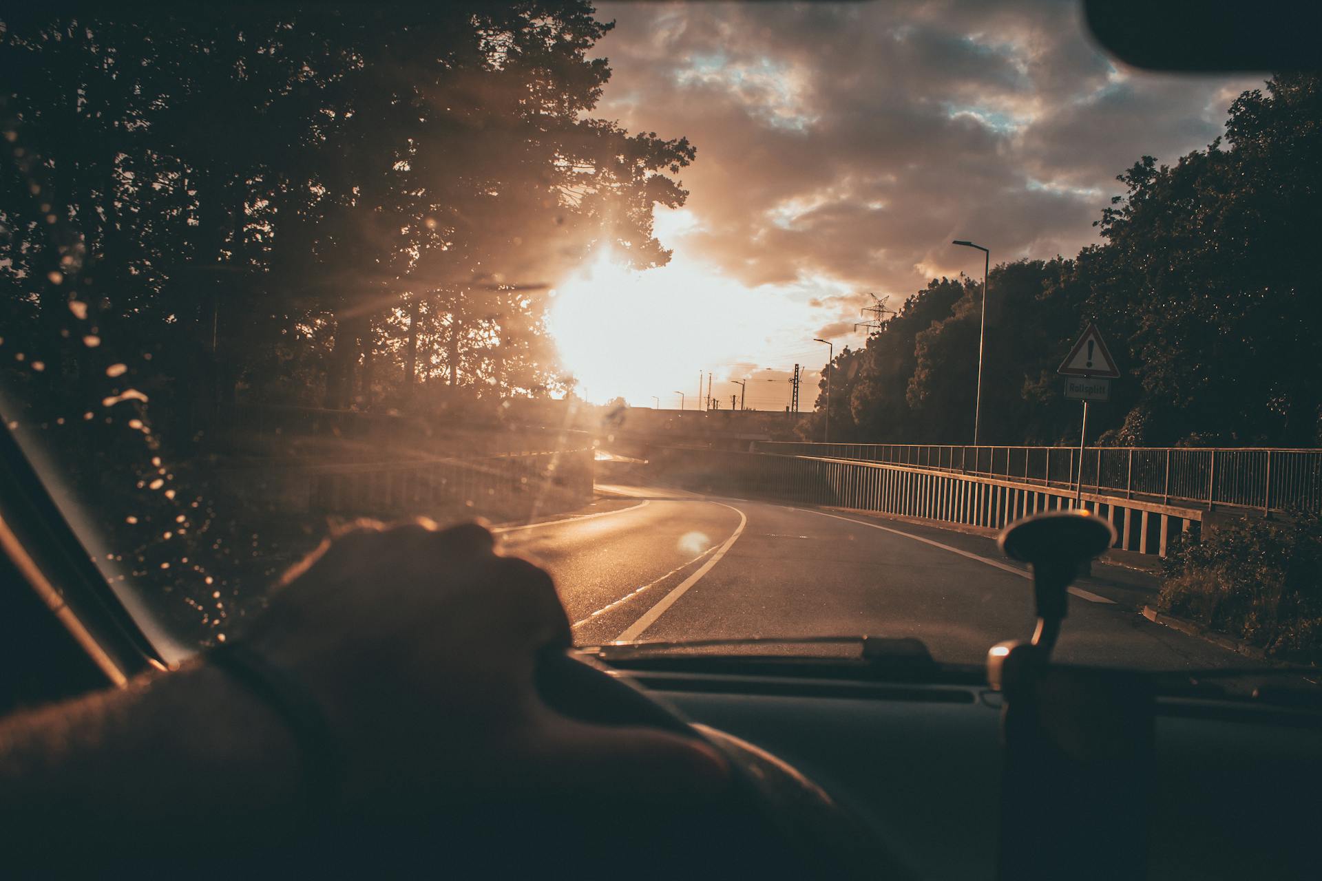 Capturing a serene drive at sunset, with a scenic road and vibrant sky.