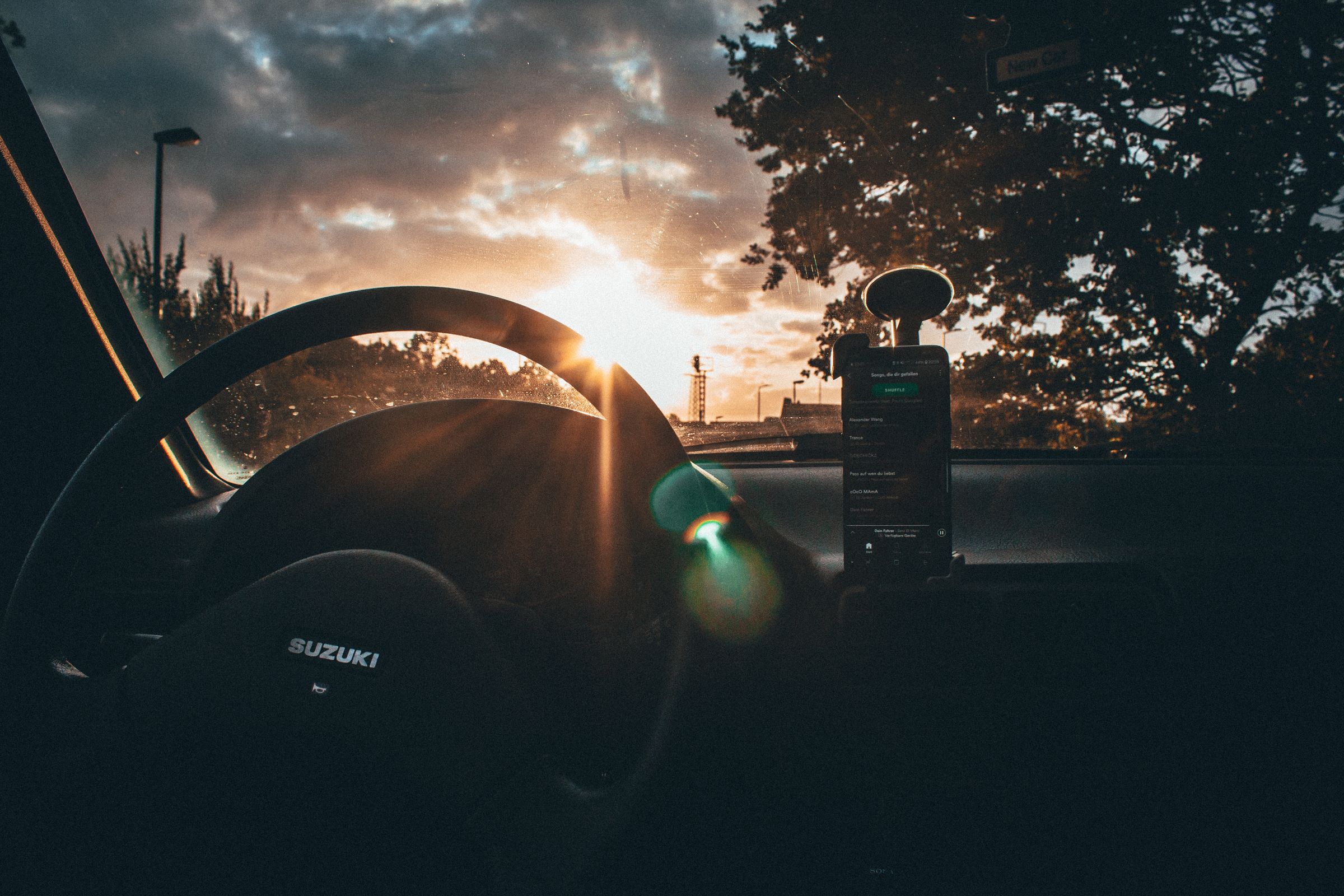 Sunlight glaring through a car windshield onto the dashboard and steering wheel