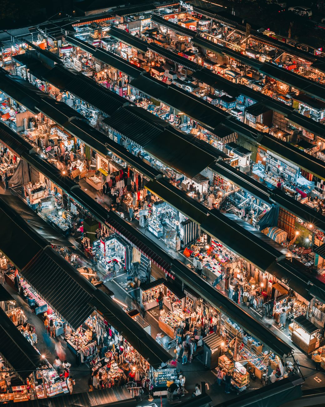 A bustling aerial view of a vibrant night market in Taiwan, showcasing diverse shopping stalls.