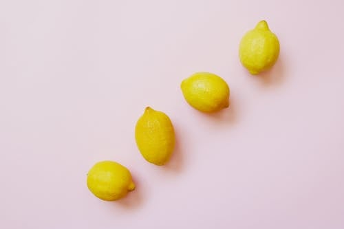Free Four Lemon Fruits Forming Straight Line on a White Background Stock Photo