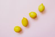 Four Lemon Fruits Forming Straight Line on a White Background