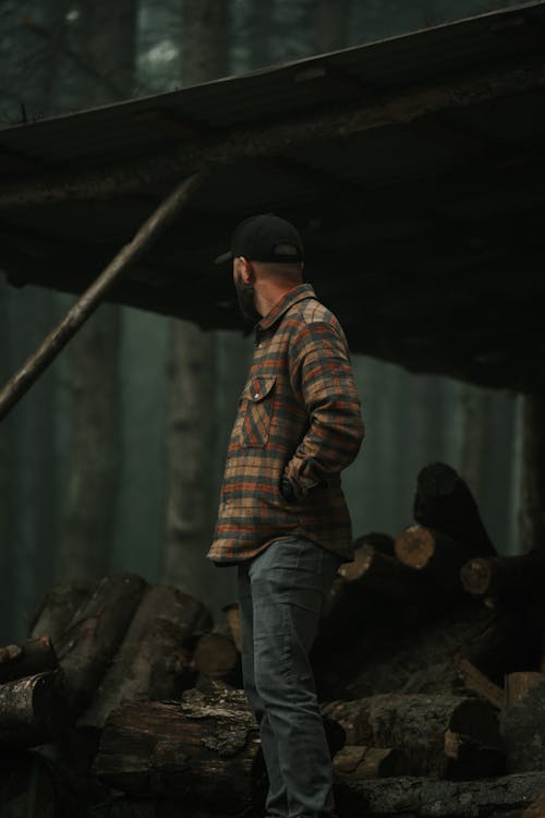 A man standing in front of a log cabin