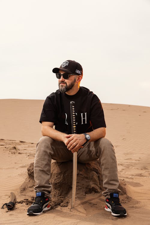 Free A man sitting on a rock in the desert Stock Photo