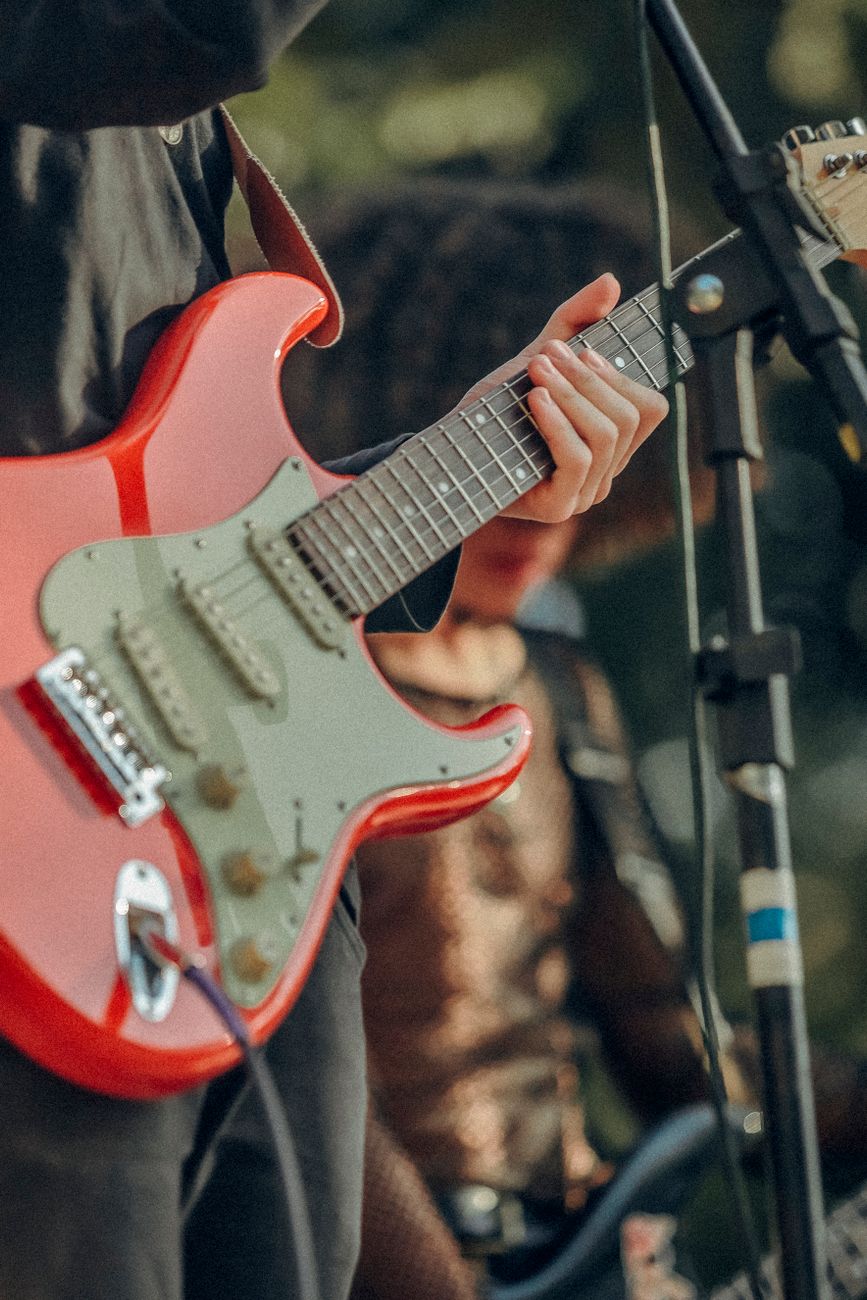 A musician skillfully plays an electric guitar at an outdoor concert.