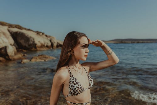 A woman in a leopard print bikini standing in the water