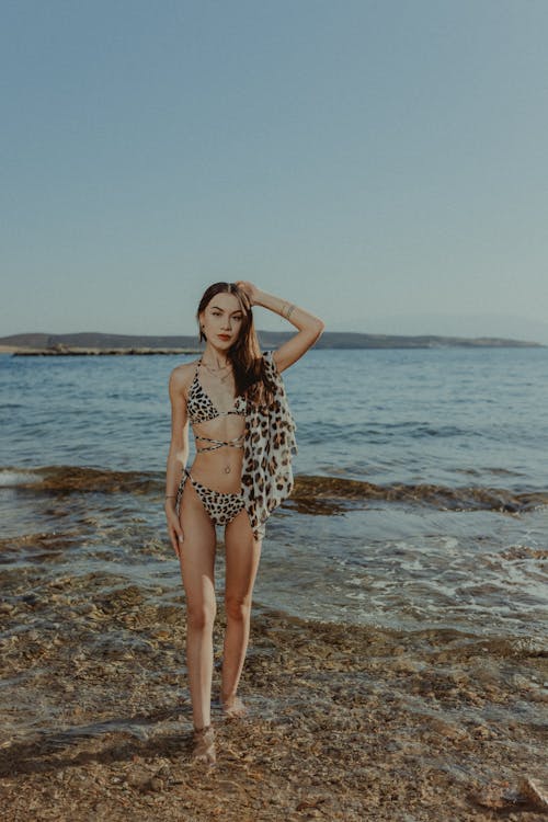 A woman in a leopard print bikini standing in the water