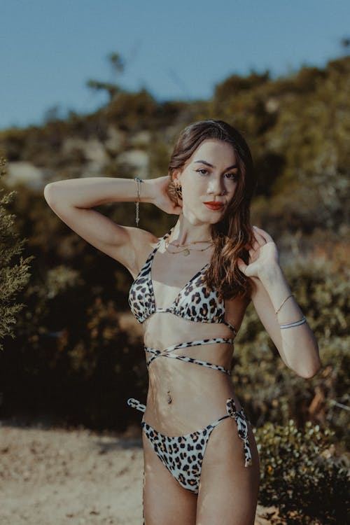 A woman in a leopard print bikini standing in the desert