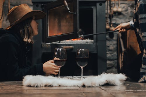 A woman in a hat and a man with a glass of wine