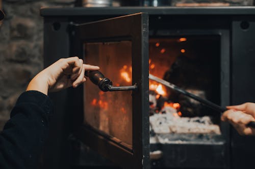 A person using a phone to light a fire in a fireplace